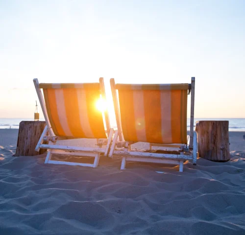 Twee vrolijk gekleurde ligstoelen om heerlijk in te relaxen bij Strandpaviljoen Zuid op het stille strand